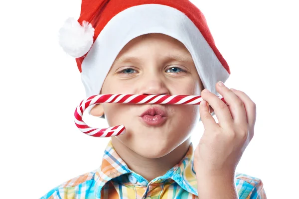 Little boy in New Year's red cap with Christmas candy cane isola — Stock Photo, Image