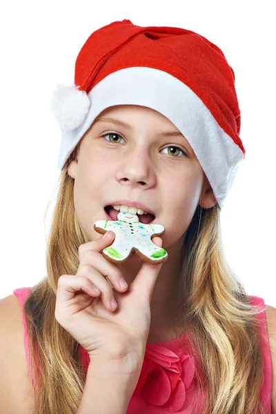 Szczęśliwa dziewczyna w Czerwonym Kapturku jedzenie na białym tle cookie Boże Narodzenie — Zdjęcie stockowe