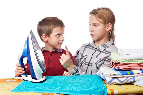 Sister helps younger brother to properly handle iron isolated — Stock Photo, Image