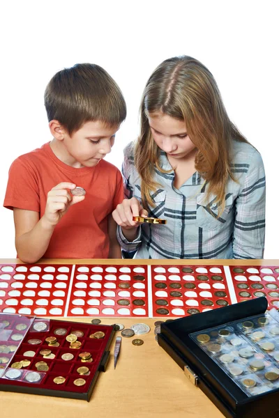 Boy and girl are considering coin collection isolated — Stockfoto