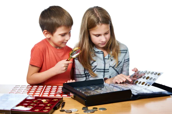 Menino e menina estão considerando coleção de moedas isoladas — Fotografia de Stock