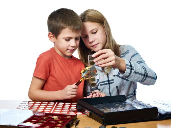 Chłopiec i dziewczynka rozważają kolekcja moneta na białym tle — Zdjęcie stockowe