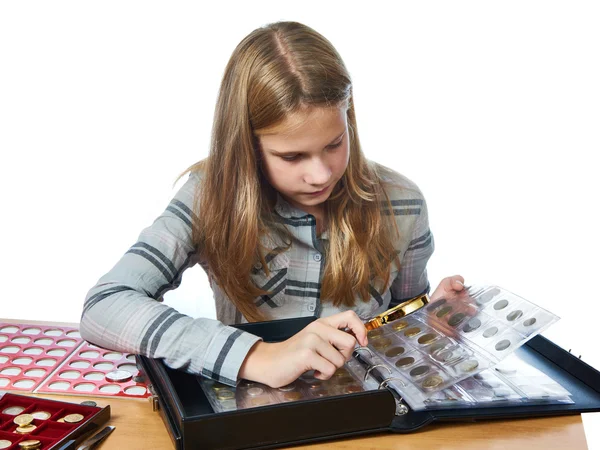 Girl inspecting her collection coins isolated — Stock Photo, Image