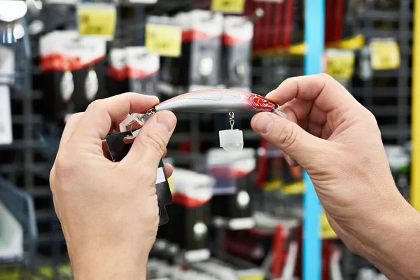 Appât leurre de pêche avec crochet dans les mains homme en magasin — Photo