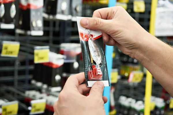 Fishing lure bait in hands man in store — Stock Photo, Image
