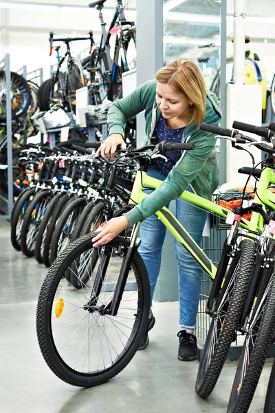 Mulher teste de bicicleta na loja de desporto — Fotografia de Stock