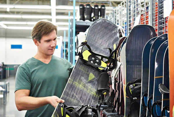 Mann wählt Snowboard in Sportgeschäft — Stockfoto