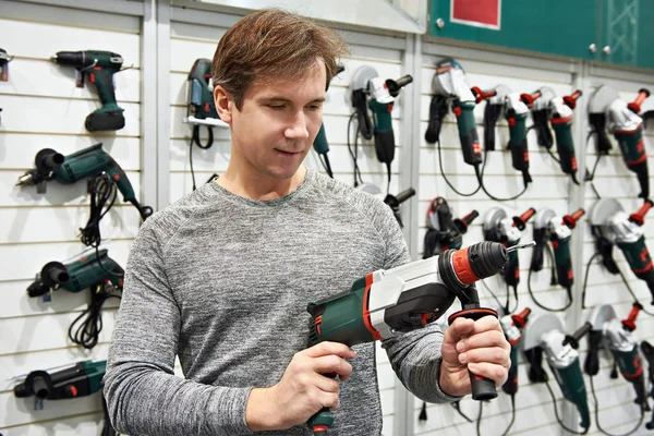 Mann mit Bohrmaschine im Baumarkt — Stockfoto