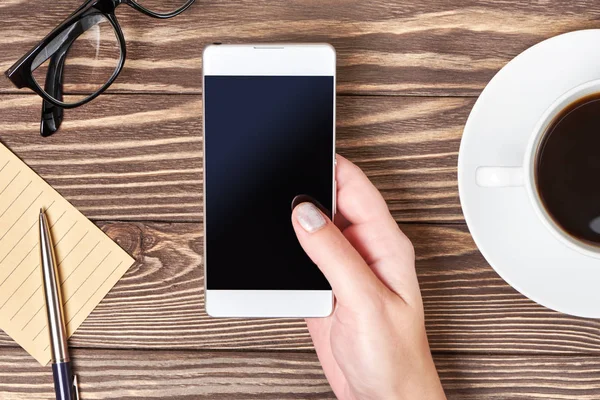 Womans hands with smartphone and cup of coffee — Stock Photo, Image