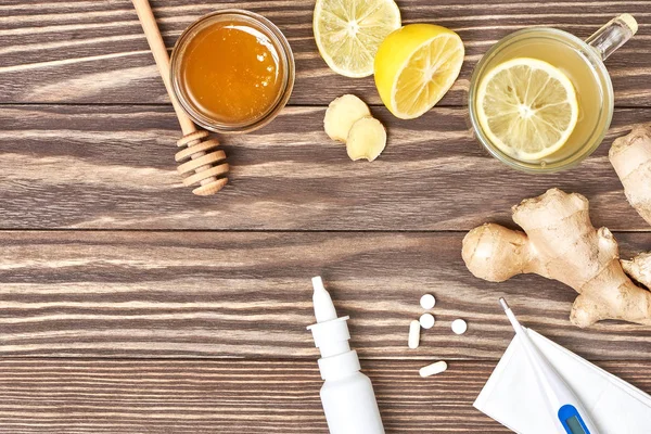 Taza de té de jengibre, miel, limón, pastillas, termómetro — Foto de Stock