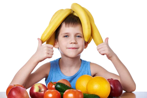 Rapaz saudável feliz com bananas e frutas isoladas — Fotografia de Stock