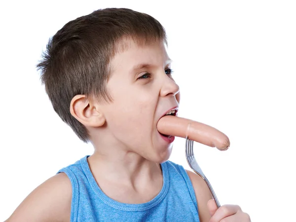 Little boy eating a sausage from fork isolated — Stock Photo, Image