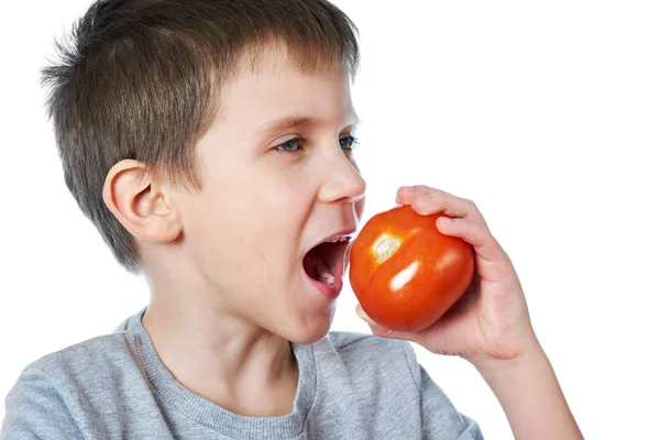 Piccolo allegro ragazzo mangiare pomodoro isolato — Foto Stock