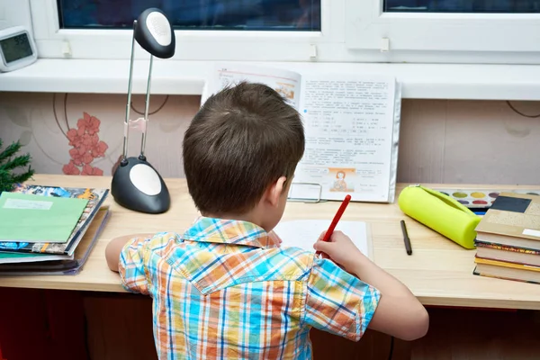 Boy does his homework at  table — Stock Photo, Image