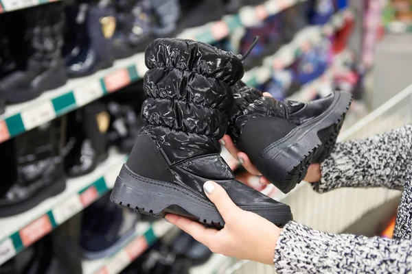 Winter boots in hands of women customers at store — Stock Photo, Image