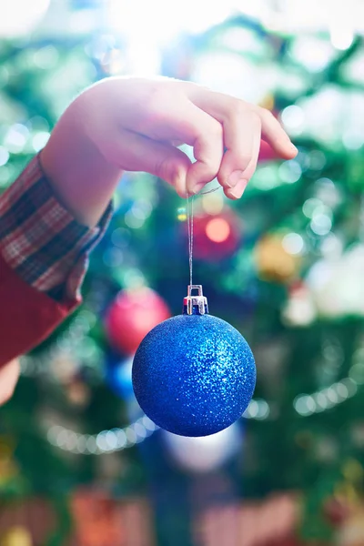 Χέρι των παιδιών με την μπλε μπάλα παιχνίδι Χριστούγεννα — Φωτογραφία Αρχείου