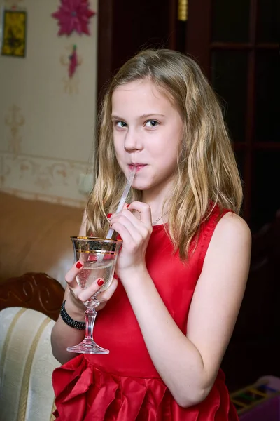 Girl in red dress drinking champagne for children — Stock Photo, Image