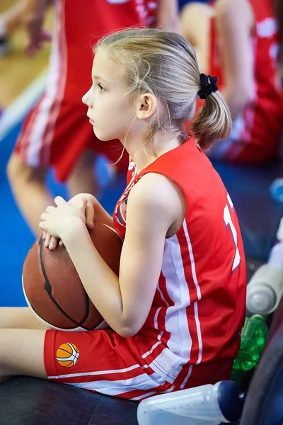 Девушка-спортсмен с баскетболом сидит на скамейке — стоковое фото
