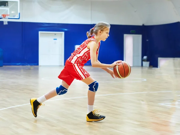 Девушка-атлет в форме играет в баскетбол — стоковое фото