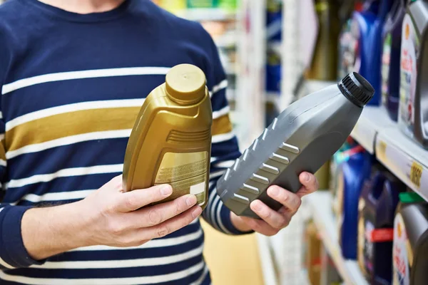 El hombre elige aceite de motor en el supermercado —  Fotos de Stock