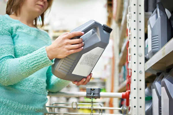 Vrouw koopt motorolie in supermarkt — Stockfoto