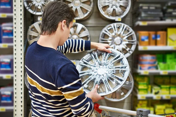 El hombre elige ruedas de aleación para sus ruedas de coche en el supermercado — Foto de Stock