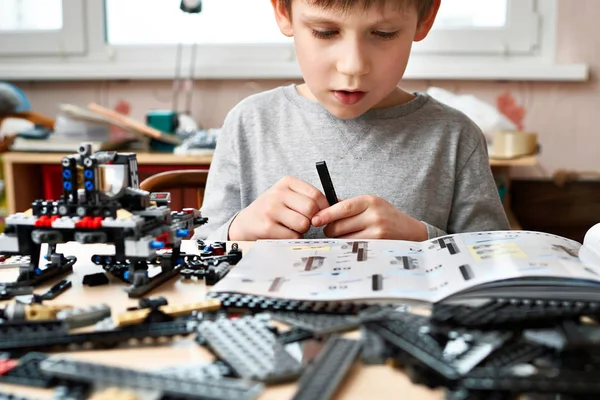 Jongetje verzamelt kunststof constructiespeelgoed van kinderen — Stockfoto