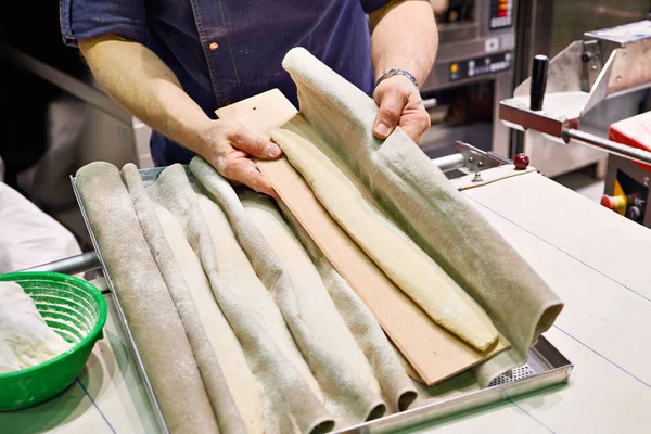 Baker prepares bread before baking — Stock Photo, Image