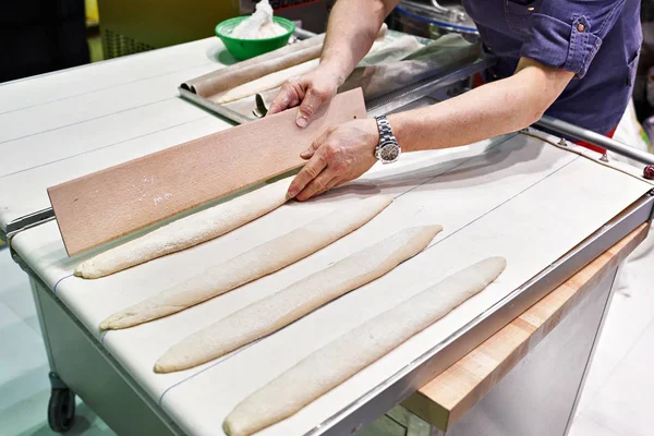 Baker prepares bread before baking — Stock Photo, Image