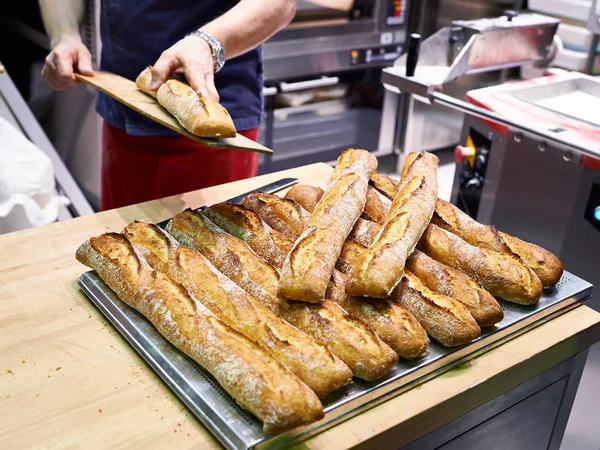Panadero con pan recién horneado en panadería — Foto de Stock