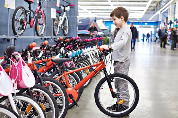 男孩在体育超市选择自行车 — 图库照片