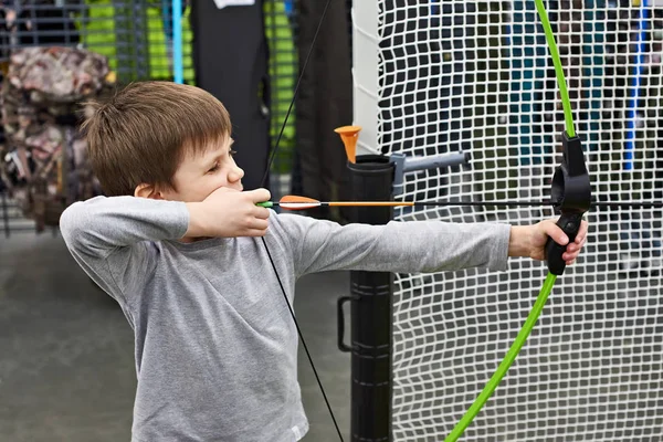 Mały chłopiec strzela przez bow w strzelnicy dla dzieci — Zdjęcie stockowe