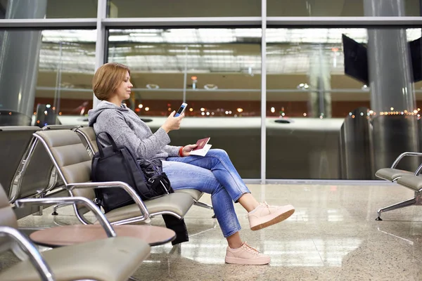 Frau mit Smartphone am Flughafen — Stockfoto
