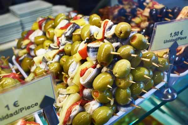 Канапе с оливками, рыбой и овощами в магазине — стоковое фото