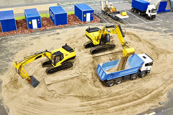 Trabajar excavadoras para cargar arena en camión. Modelo en miniatura —  Fotos de Stock
