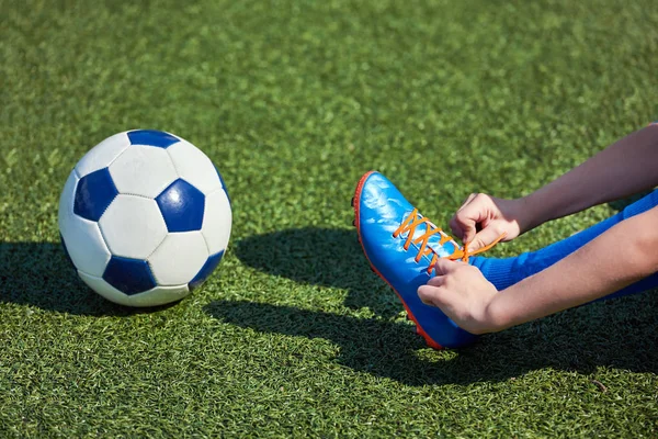Çocuk futbol futbol onu çimenlerin üzerinde çizme dantel bağlama — Stok fotoğraf
