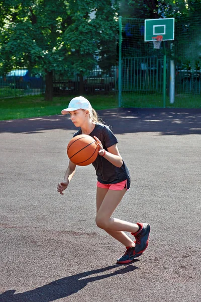 Девушка баскетболистка бегает с мячом — стоковое фото