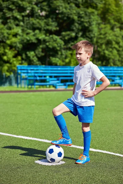Chłopiec piłkę nożną piłki nożnej buty z piłką na trawie — Zdjęcie stockowe
