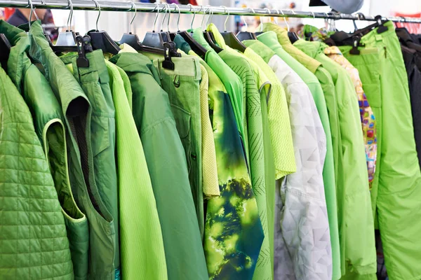 Куртки, жилеты и дождевая одежда на вешалке в магазине — стоковое фото