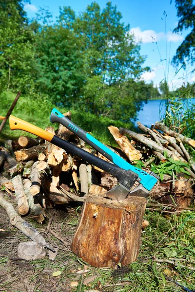 Zwei Äxte und Brennholz in der Naturlandschaft — Stockfoto