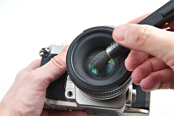 Cleaning photographic lens from dust with brush