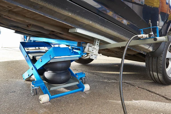 Car lifted by pneumatic jack — Stock Photo, Image