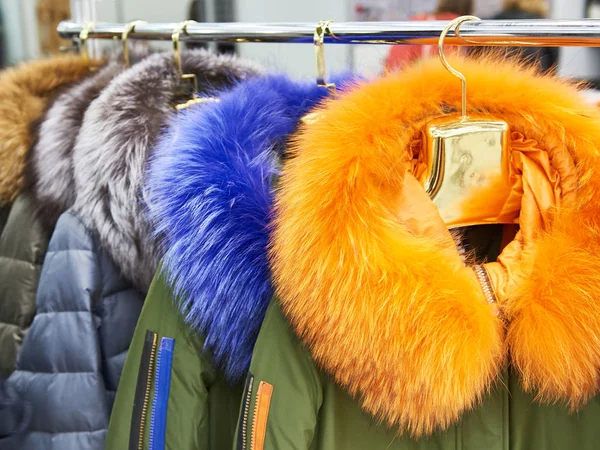 Casacos de inverno com coleiras de pele coloridas na loja de roupas — Fotografia de Stock