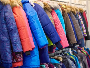 Winter jackets on hanger in store clipart