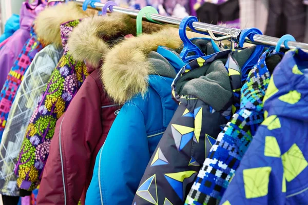 Дитячі зимові куртки на вішалці в магазині — стокове фото