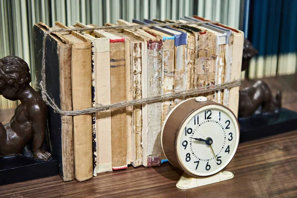 Old books tied up with rope and alarm clock — Stock Photo, Image