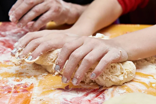 Childrens hands knead dough — Stock Photo, Image