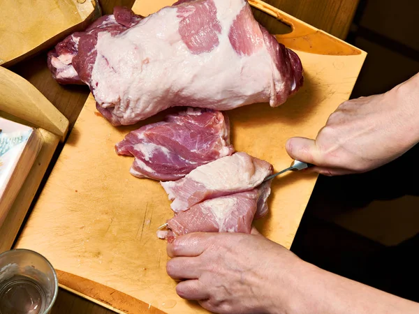 Жіночі руки нарізали свиняче м'ясо — стокове фото