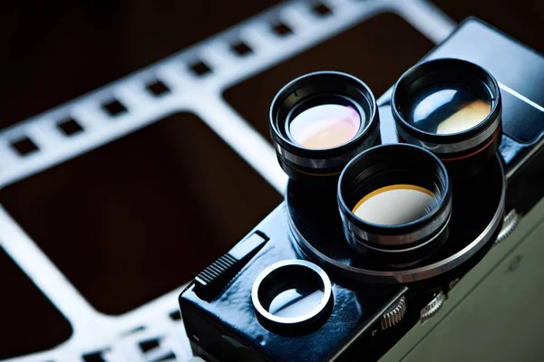 Câmera de filme retro velho no fundo do filme de perfuração — Fotografia de Stock