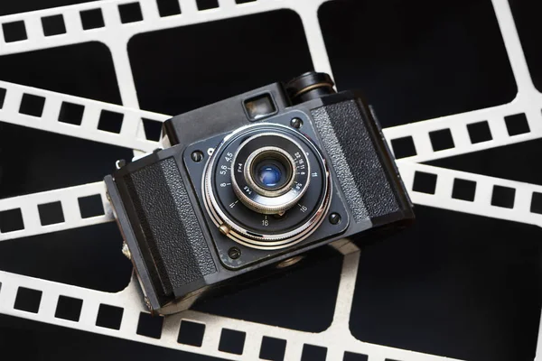 Старая камера ретро-дальномер на фоне перфорации пленки — стоковое фото